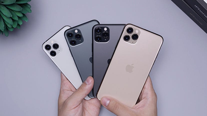 A man holds a group of iPhones like playing cards.