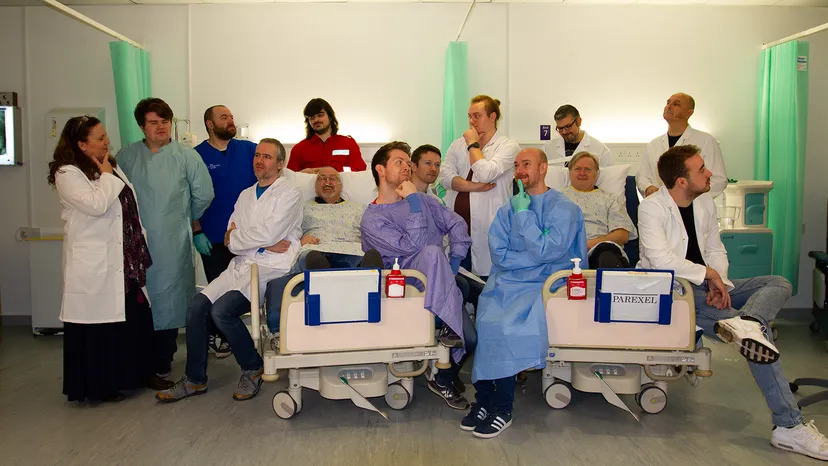 The Two Point Hospital team poses in hospital garb for a photoshoot.