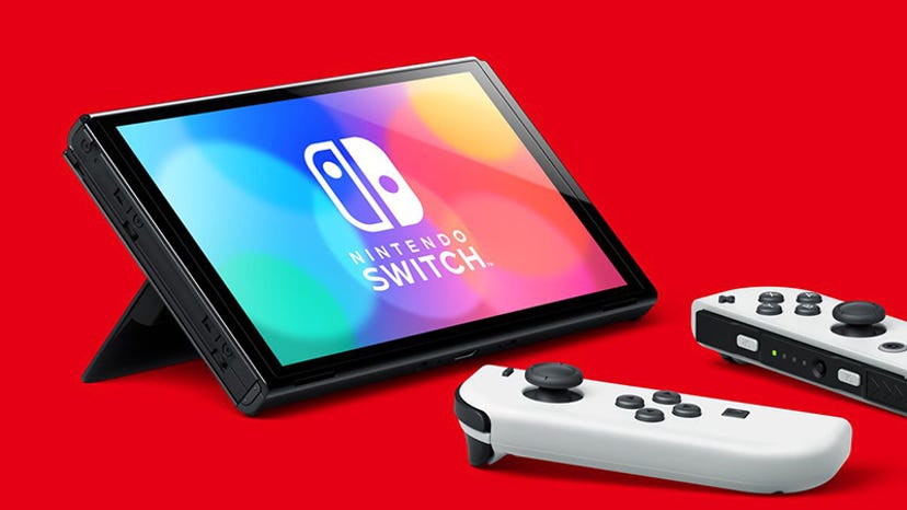 The Nintendo Switch OLED. The Joycons have been removed and the device is resting on its kickstand.
