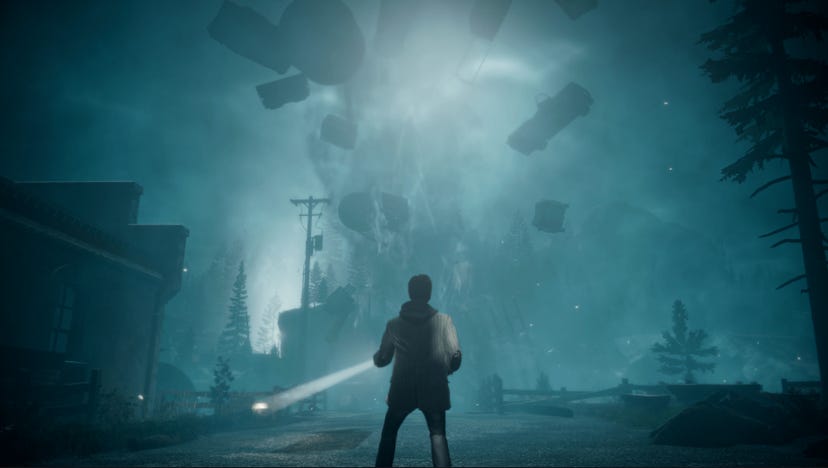 A screenshot from Alan Wake Remastered. Alan looks at a waterspout flinging trucks and other debris out of a road.