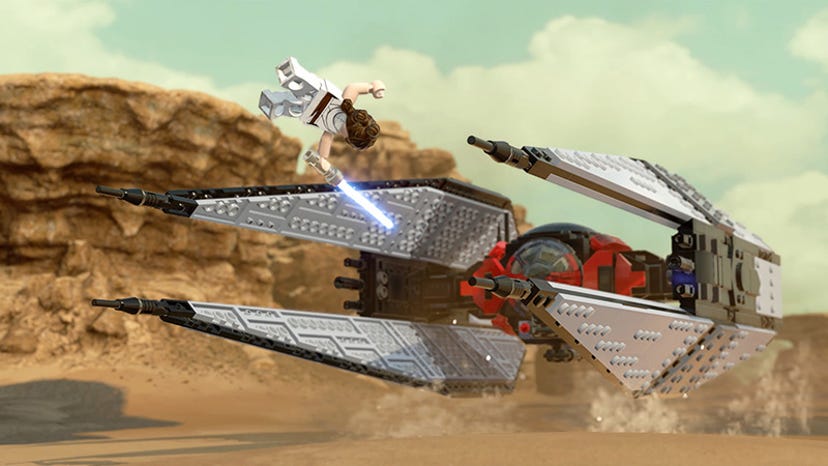 A screenshot from LEGO Star Wars: The Skywalker Saga. A LEGO version of Rey leaps over a LEGO TIE Whisper.