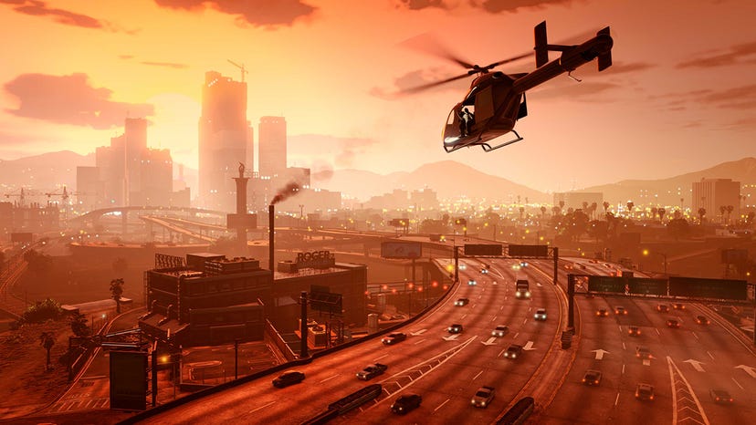 A screenshot from GTA V showing a helicopter flying toward a city at sunset