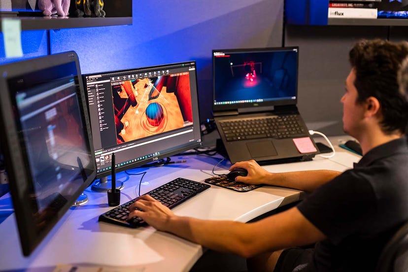 Photograph of a game developer working on their computer.