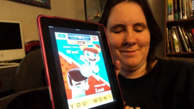 Debbie holding a tablet showing a hanging with friends endgame screen