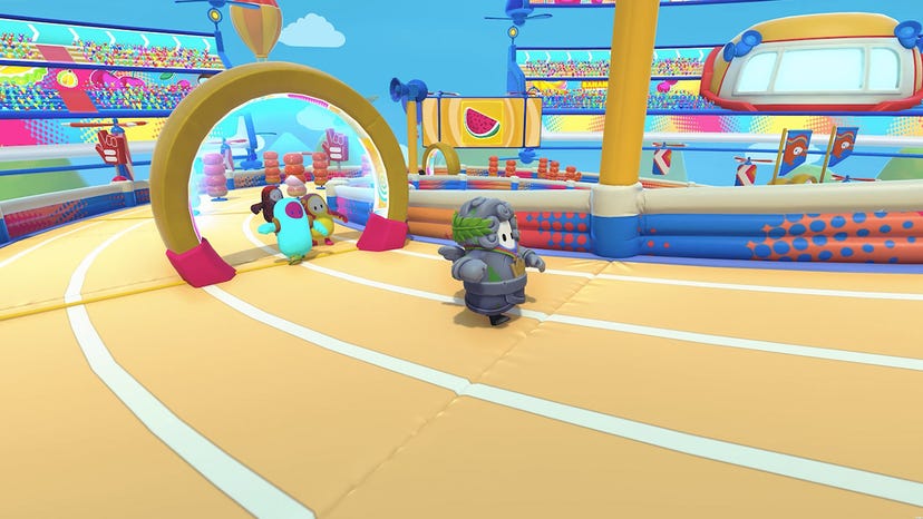 A screenshot of a Fall Guys bean bumbling around a race track