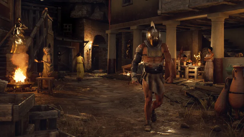 Several people and golden statues in ancient Roman garb populate a dirt road in an ancient Roman city. One woman warms herself by a fire, while another stands near an outdoor dining area. A lightly armored guard walks along the road.