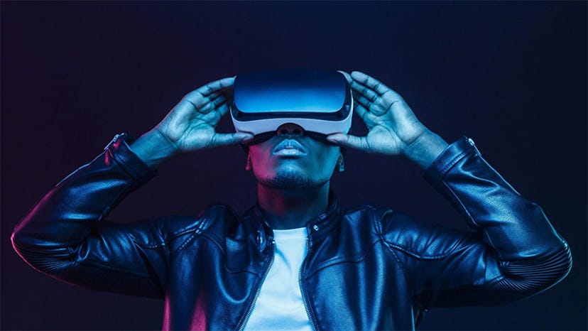 An African American man uses a VR headset.