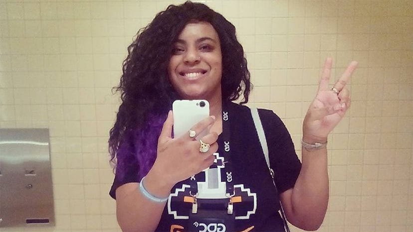 A photograph of Undrea Leach. She is throwing a "peace" sign while taking a mirror selfie at GDC.