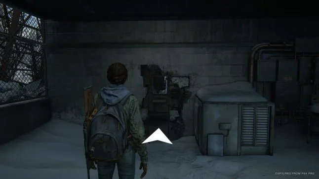 The player in front of a large hole in the wall, with a navigation assistance arrow pointing towards it