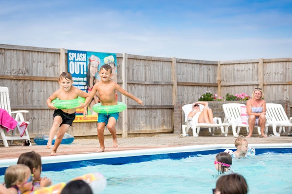 Kids jumping in swimming pool Steeple Bay