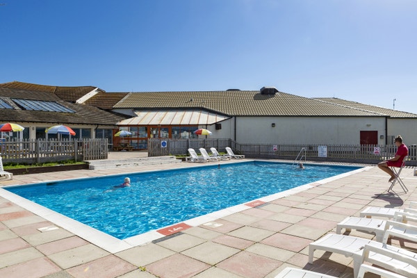 A woman swimming in the outdoor pool at Landscove Holiday Park in Devon