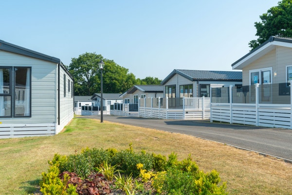 A row of caravans with decking at Golden Sands Holiday Park in Devon