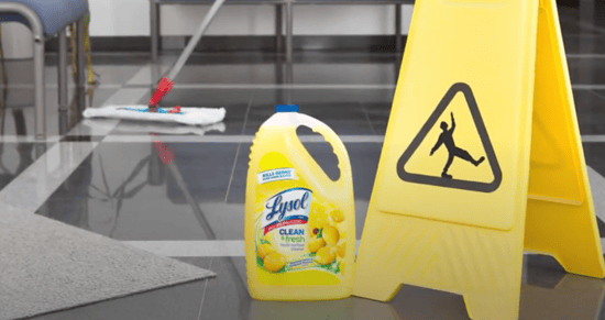 wet floor sign next to a mop and Lysol cleaner