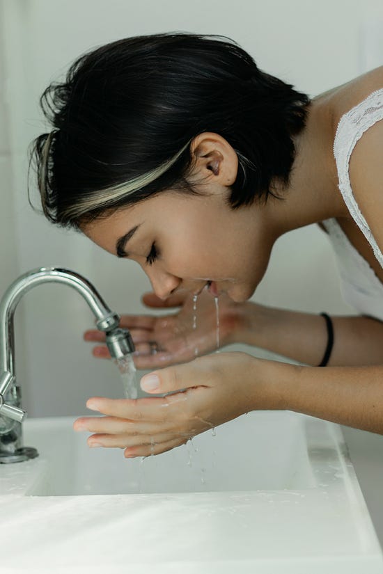 Woman Washing Her Face With Water 