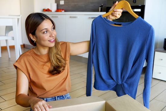 Woman holding a blue shirt on a hanger