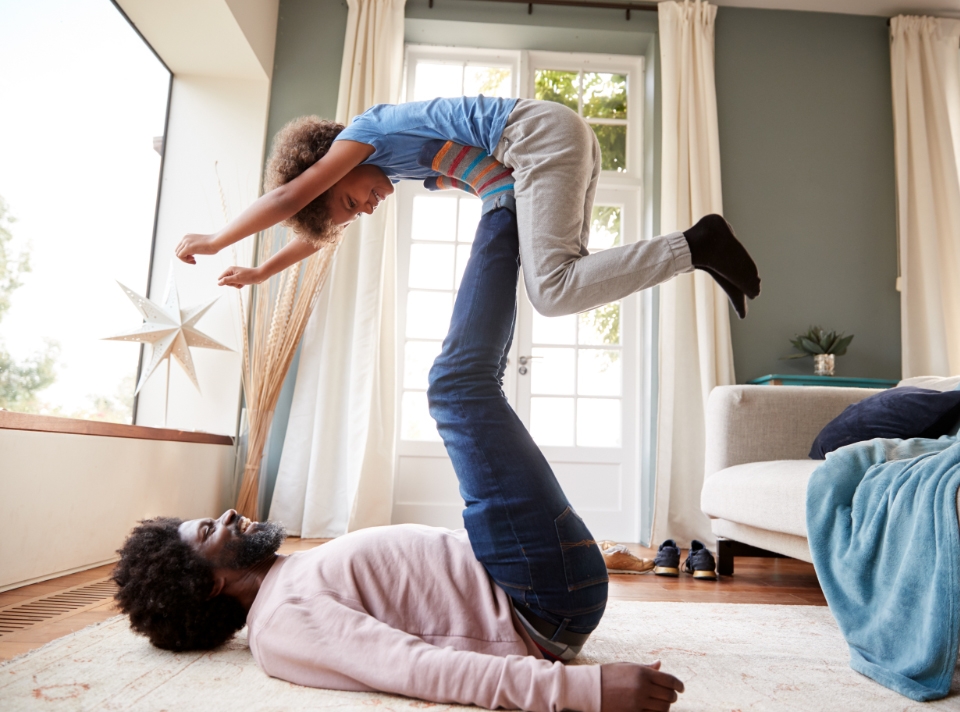 A pre school boy Playing with his father on the clean flor
