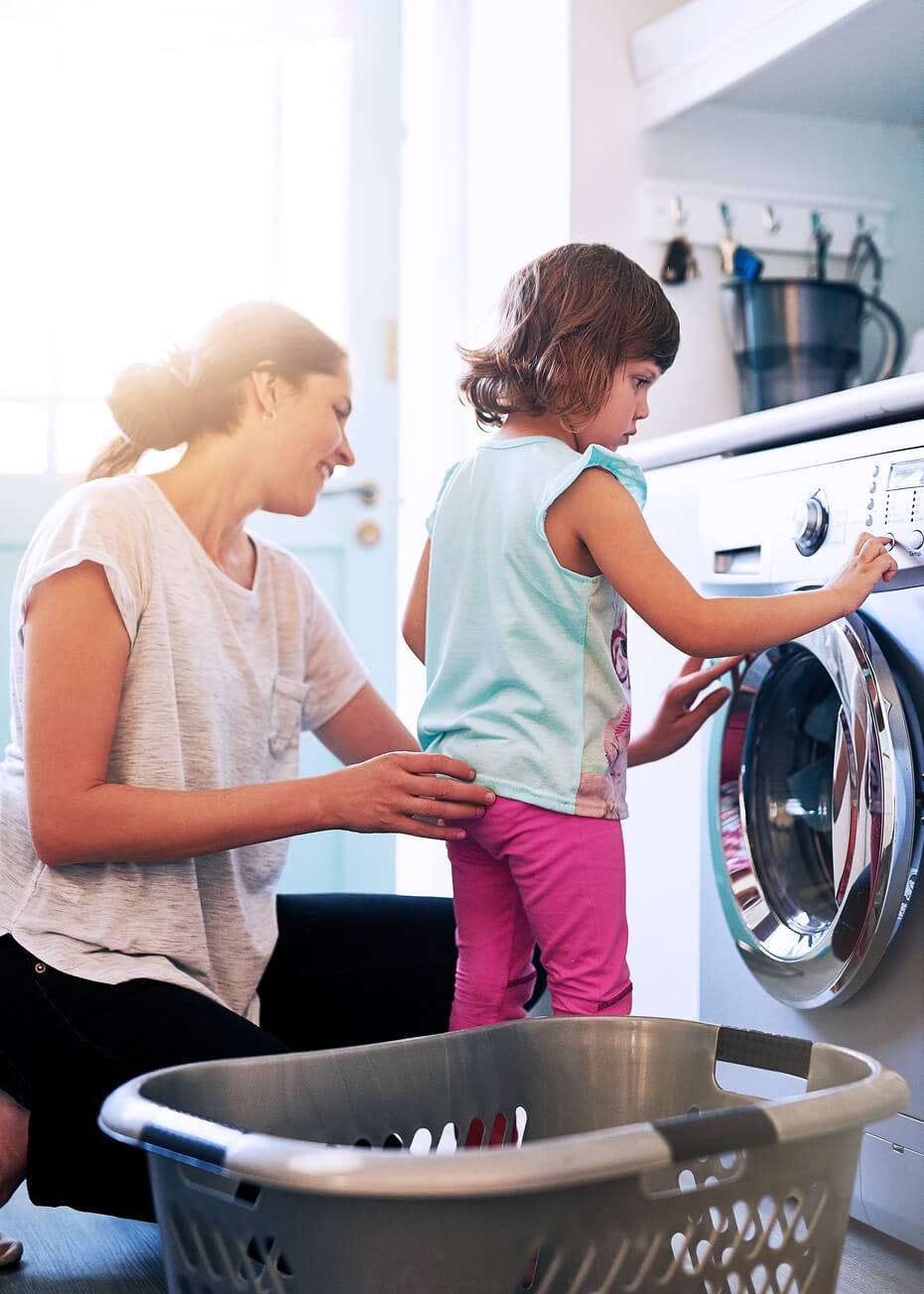 mother teaching the kid how to wash clothes