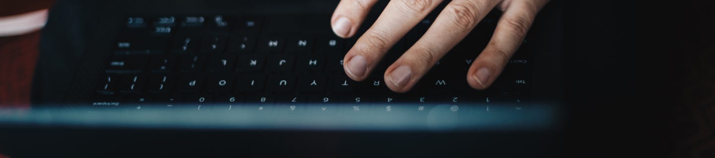 Upside down laptop with a hand hovering over a laptop
