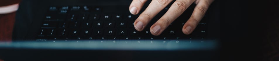 Upside down laptop with a hand hovering over a laptop