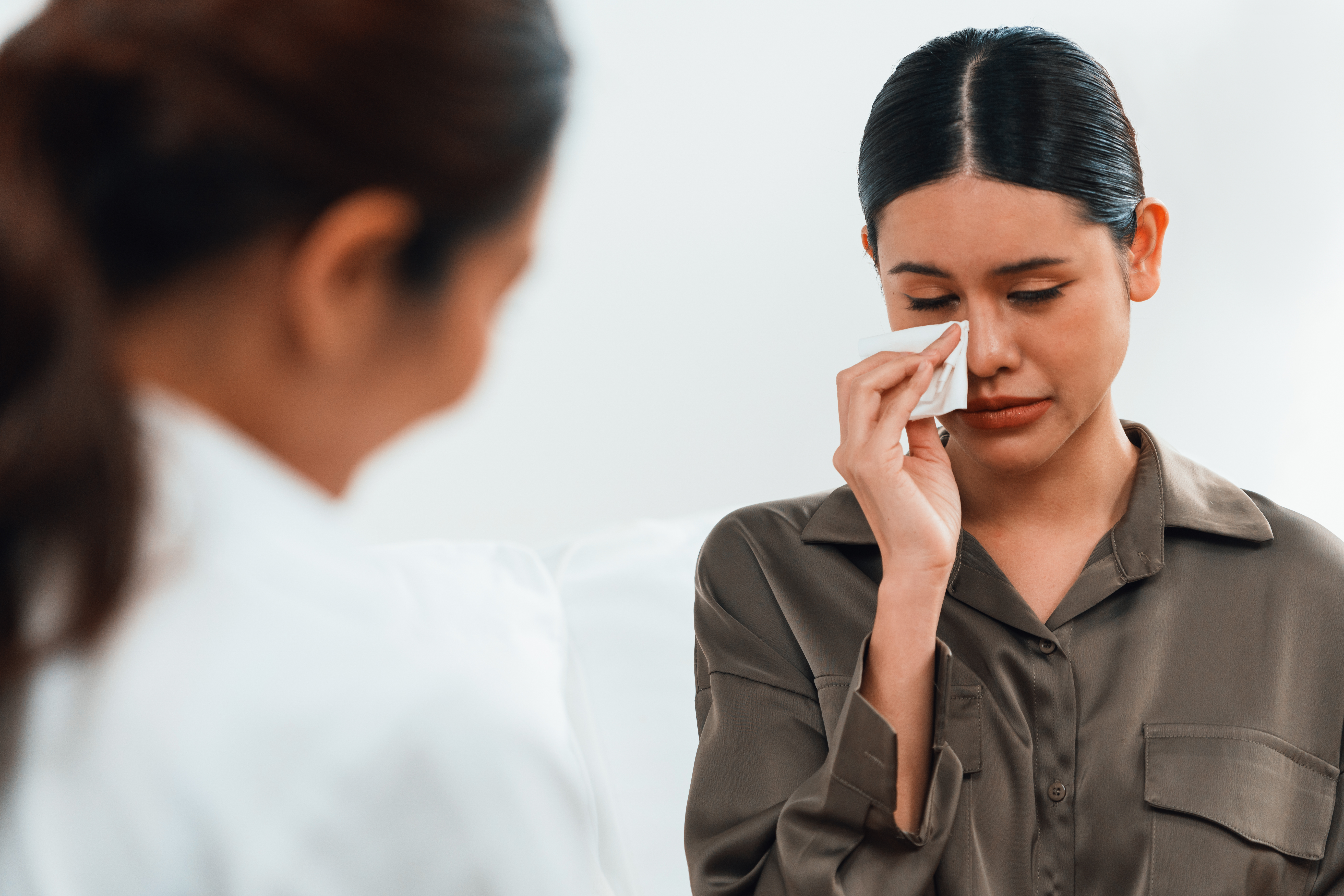 A woman dabbing her eye with a tissue