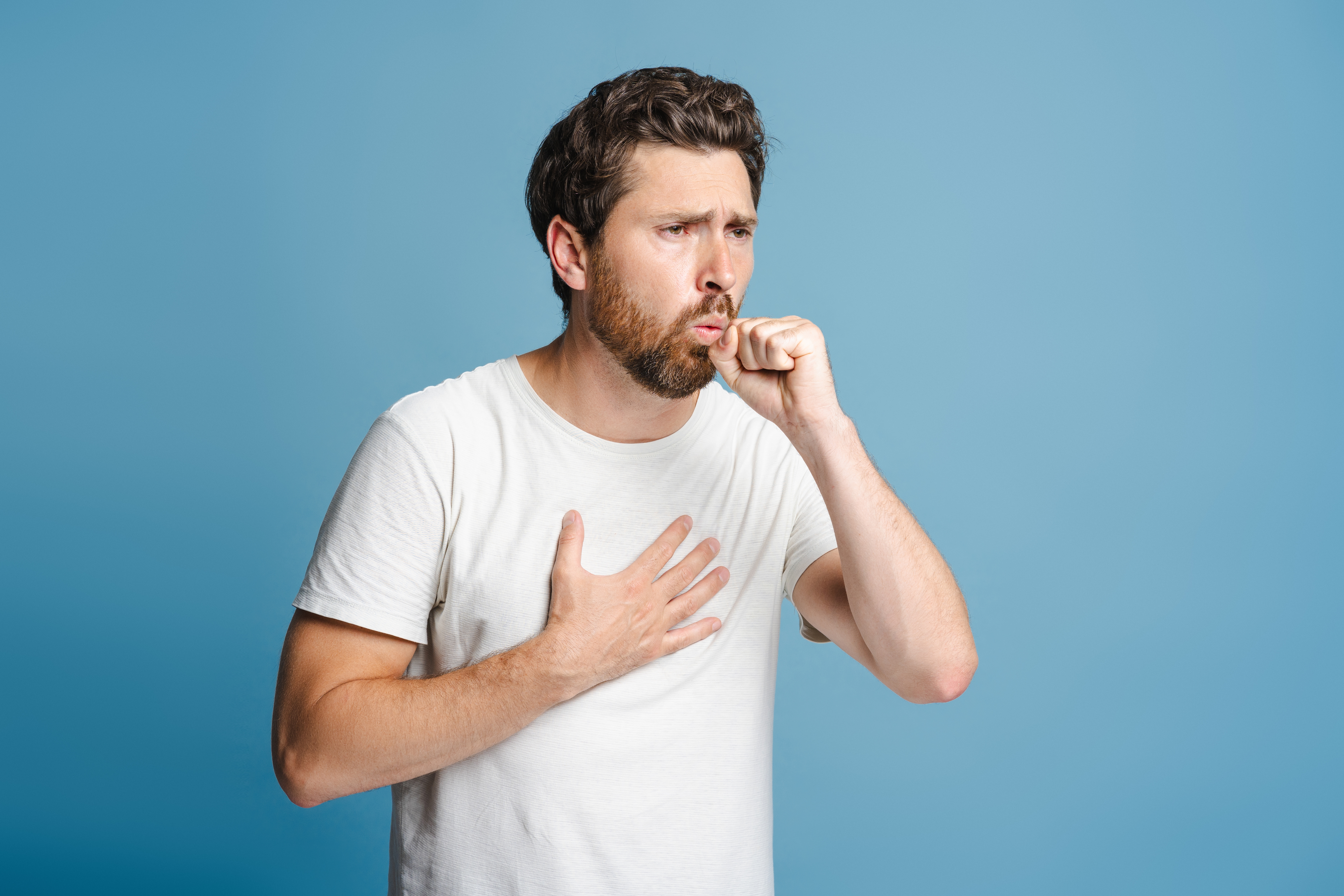 Man covering mouth while coughing