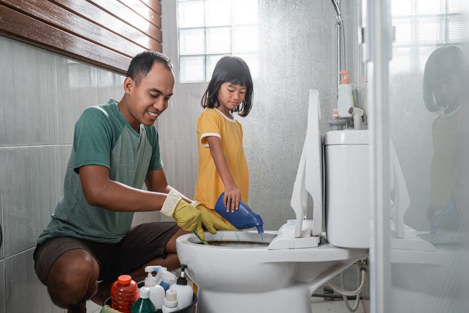 Man and kid cleaning a Western toilet together