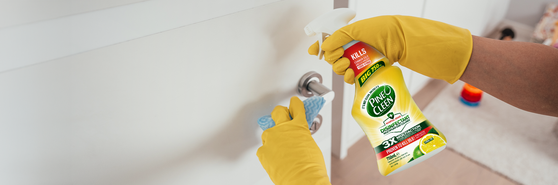 Person cleaning door handle with Pine O Cleen Disinfectant Multipurpose Cleaner