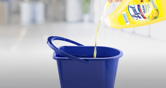 pouring cleaner into a mop bucket