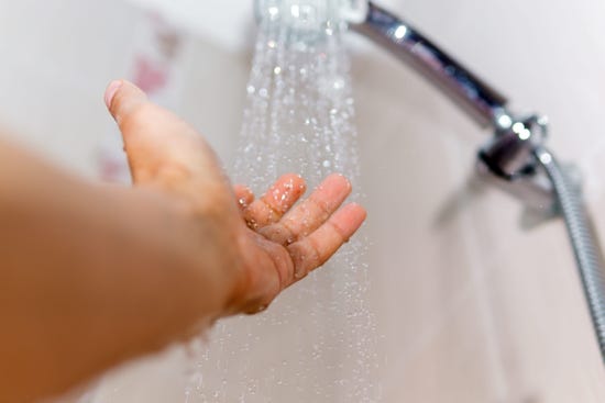 Hand catching water in the shower