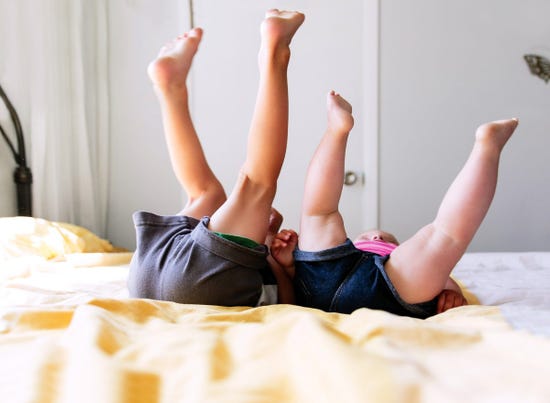 two kids laying on bed