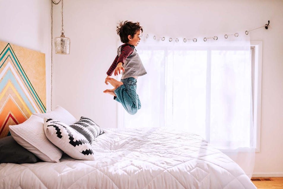 kid jumping on bed