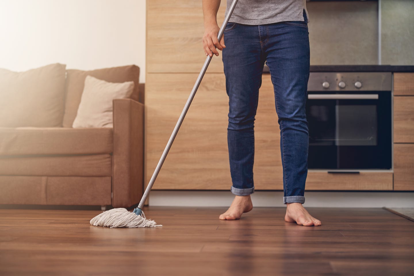 A person cleaning the hardwood floors with a mop