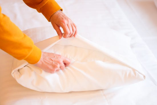 Woman inserting a pillow into a pillowcase