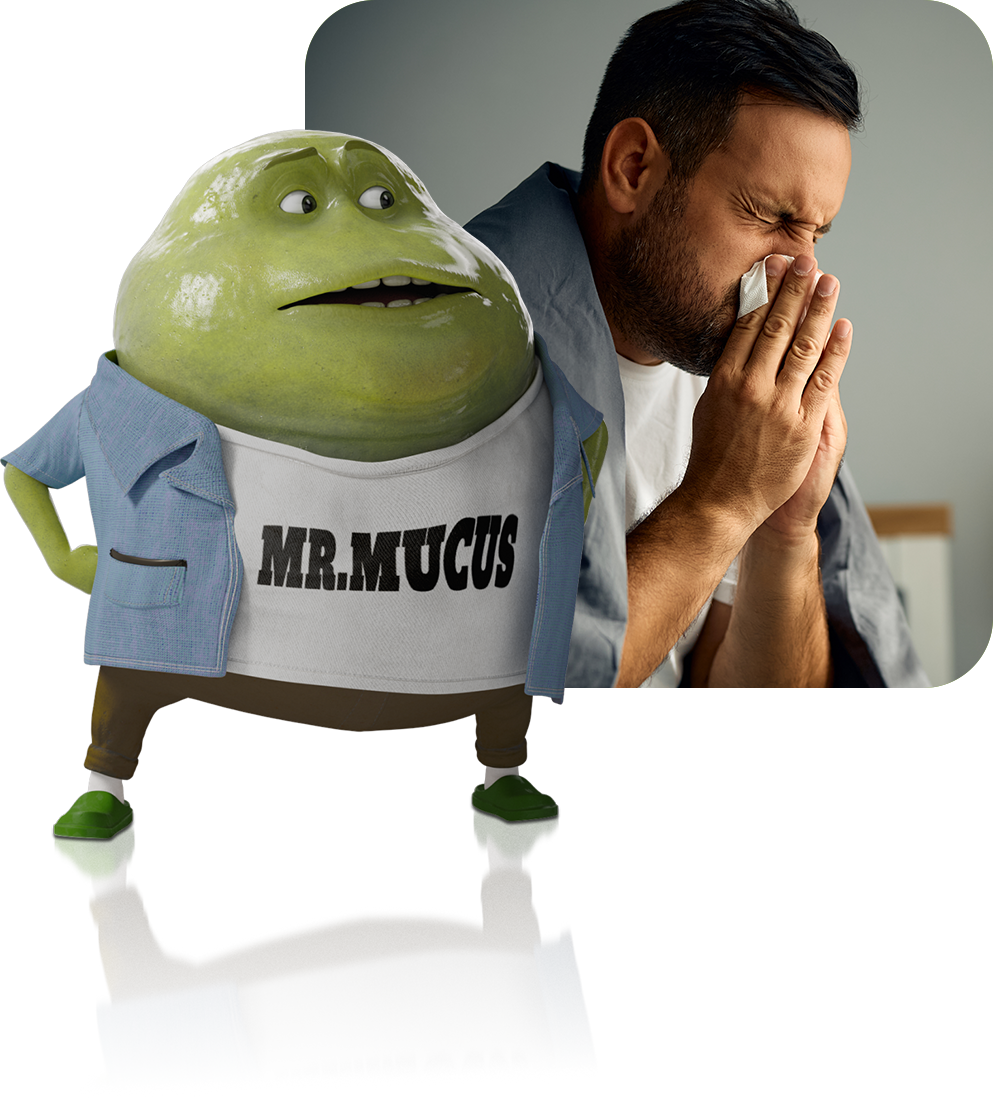 Mr. Mucus standing next to a photo of man with a cold or flu virus blowing his nose into a tissue