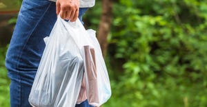 person walking with plastic bag filled with groceries