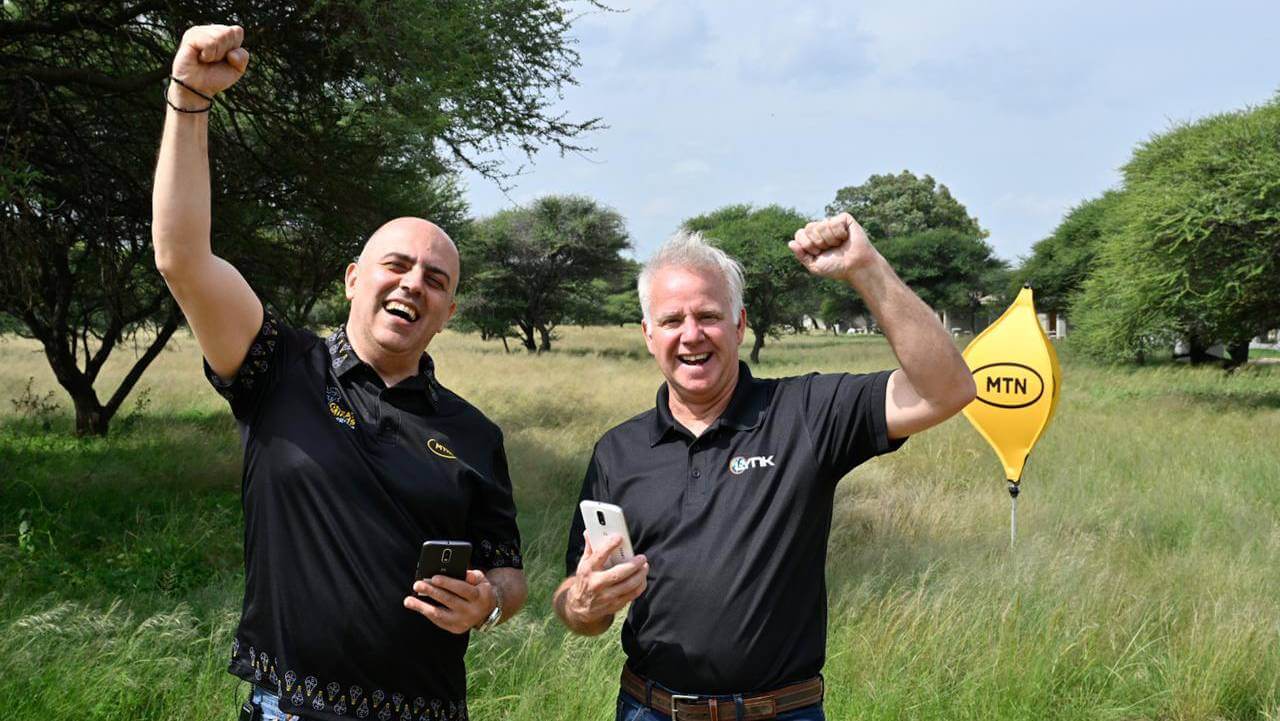 MTN SA's Rami Farah and Lynk Global's Dan Dooley raising their arms and smiling. 