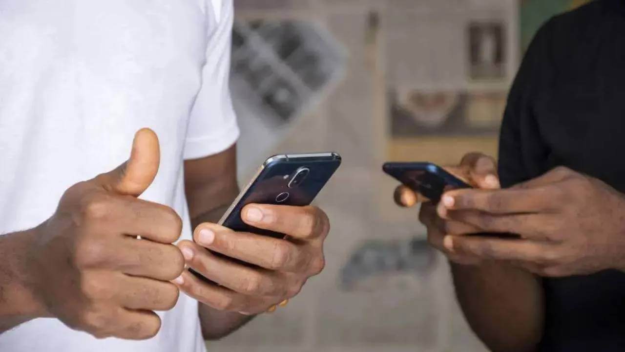 Two hands each holding a cellphone