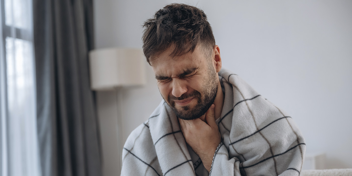 Hombre adulto con dolor de garganta