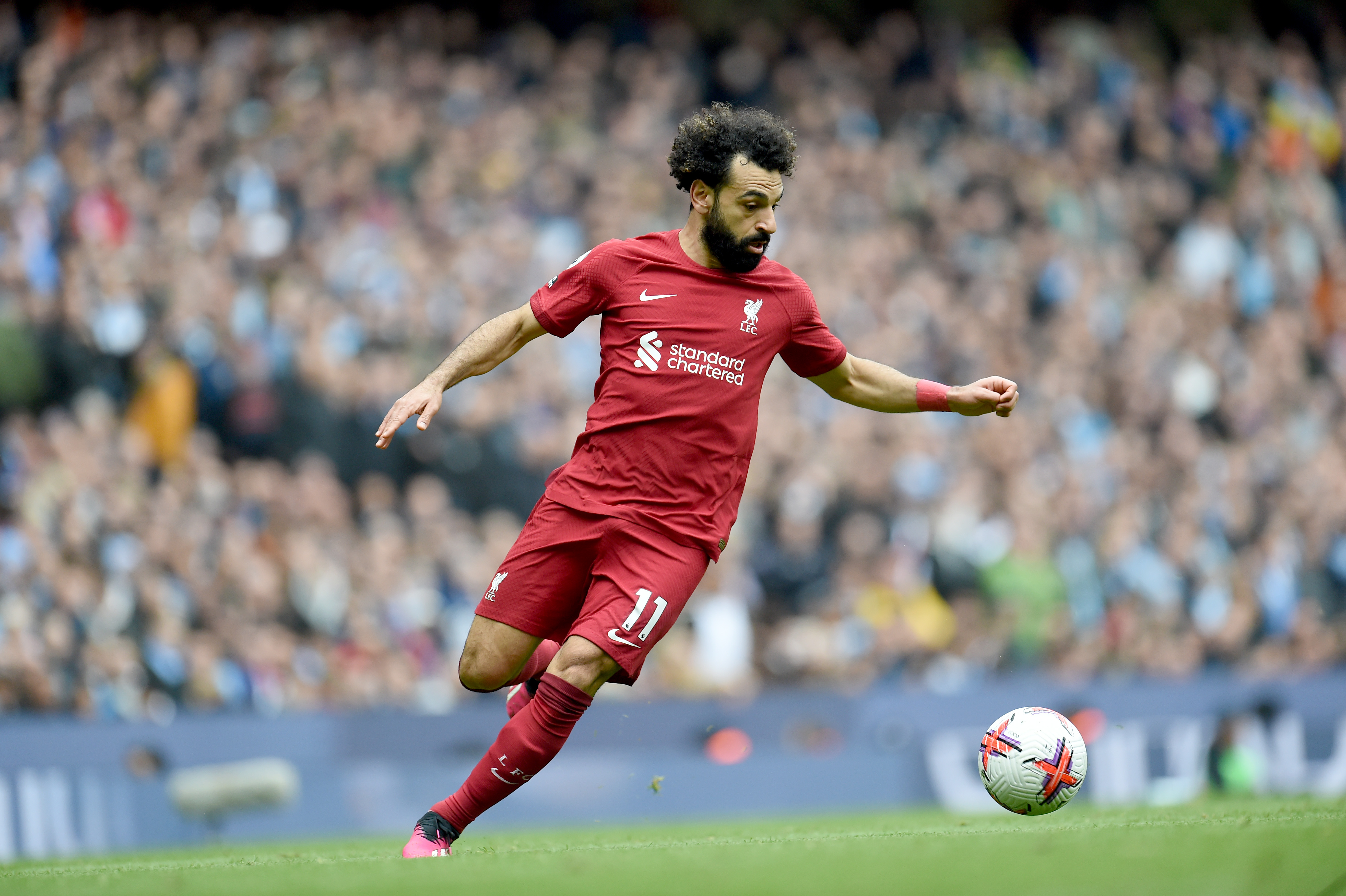 Mohamed Salah controlling the ball in a Liverpool home shirt during a Premier League match