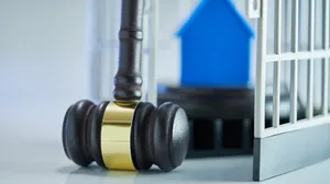 model house in a cage and the judge's gavel model house in a cage and the judge's gavel