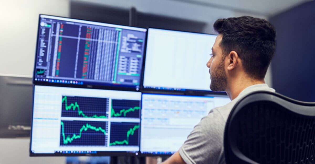 man_with_multiple_monitors_with_trading_data.jpg