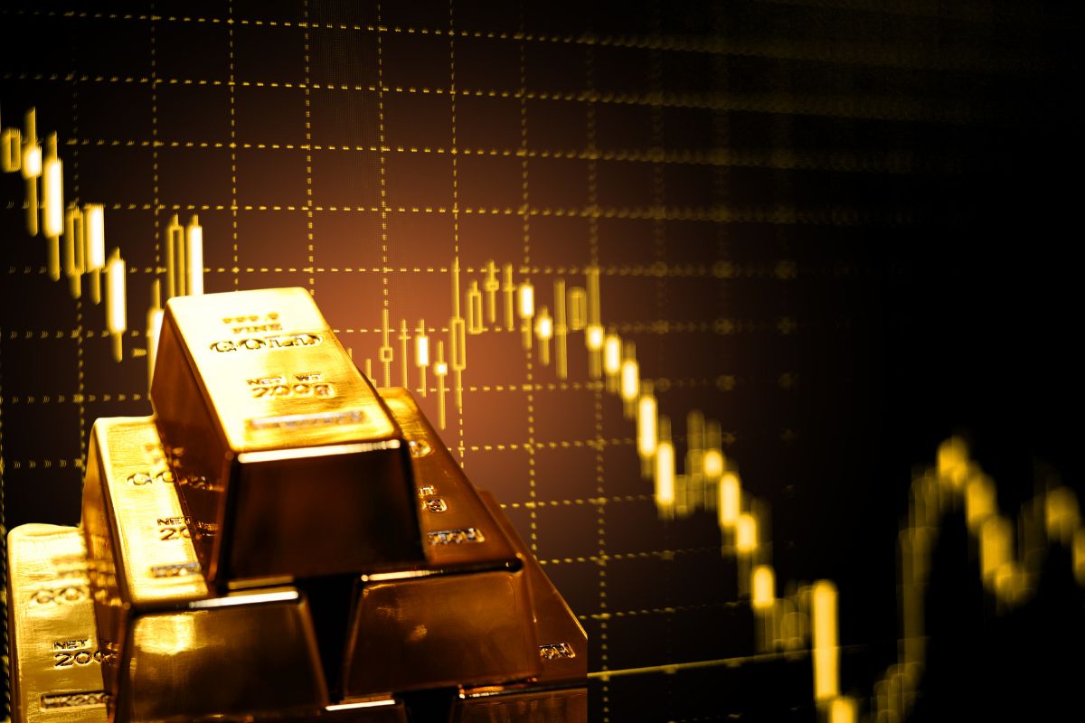 Gold bars in front of candlestick chart illustrating a trader trading gold