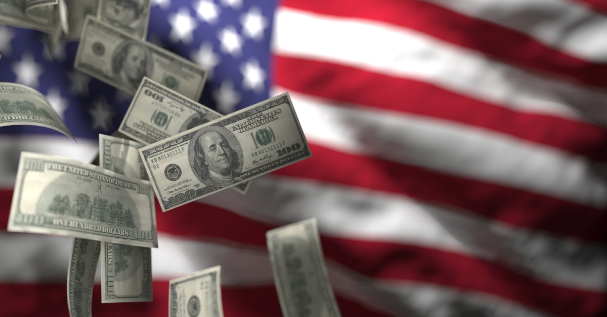 US dollars falling in front of American flag amid tariff tensions