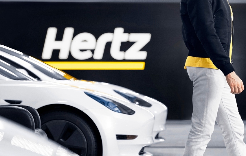 Tom Brady with a Tesla at an airport Hertz