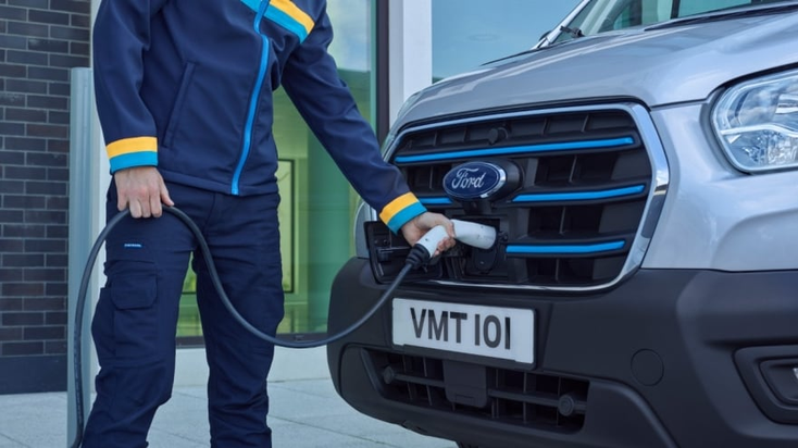 A person recharges a Ford EV A person recharges a Ford EV