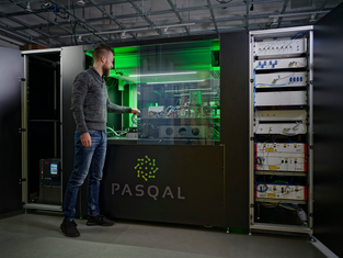 A person stands next to a Pasqal quantum computer