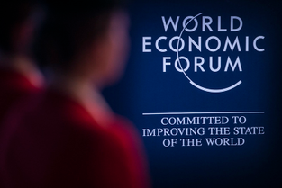 A person passing in from of the WEF logo at a forum