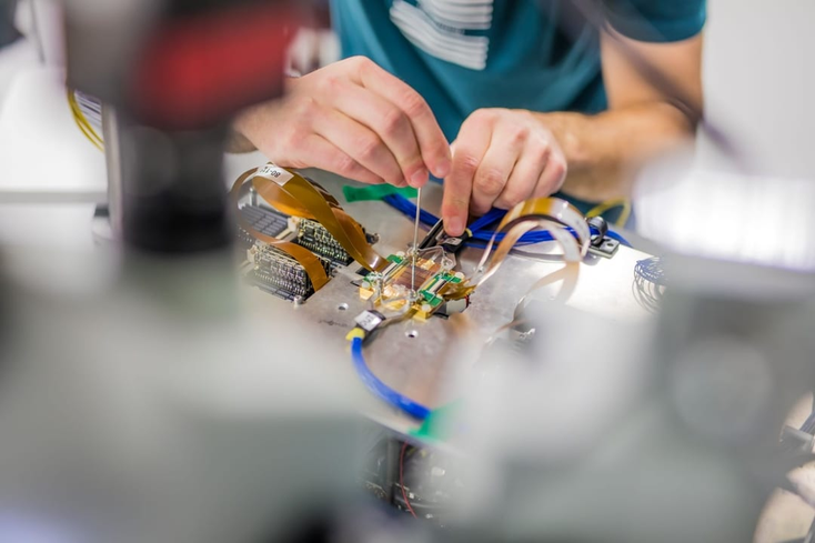 A person works on a QuiX photonic quantum processor