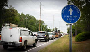 A line of traffic and an evacuation route sign