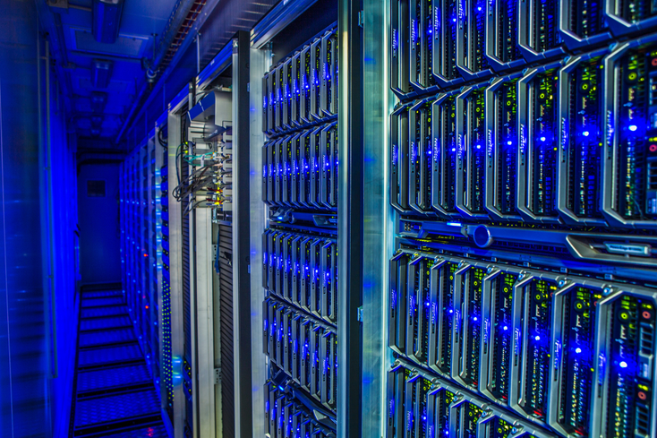 A close up of data center racks lit in blue